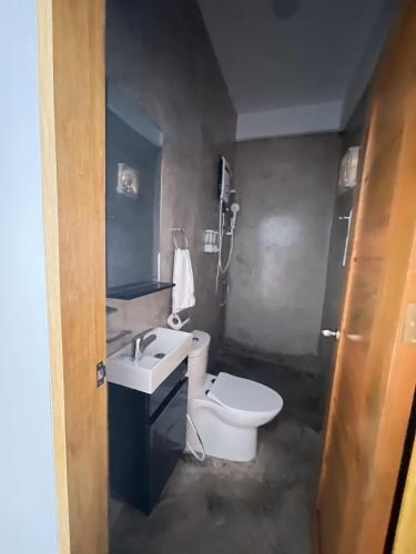 a bathroom with a white toilet and a sink at Sunset Paradise Moalboal in Moalboal