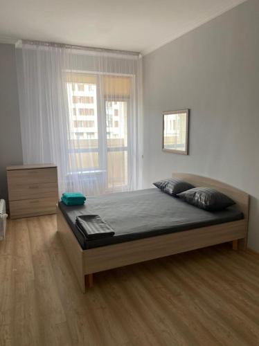 1 dormitorio con 1 cama grande en una habitación en Красивая уютная двухкомнатная квартира в Экспо, en Taldykolʼ