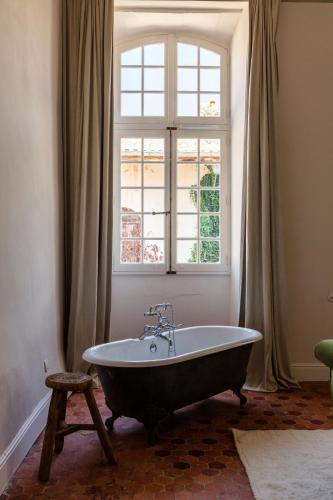 une baignoire dans une pièce avec une fenêtre dans l'établissement Maison Salix, à Vallabrègues