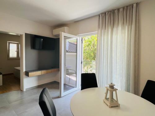 comedor con mesa y puerta corredera de cristal en Apartmani AViS, en Selce