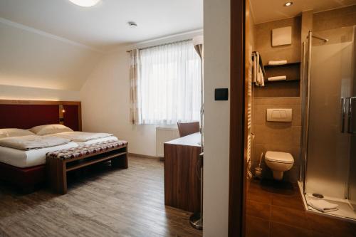FriesachにあるGästehaus Thomahanのベッドとバスルーム付きのホテルルームです。