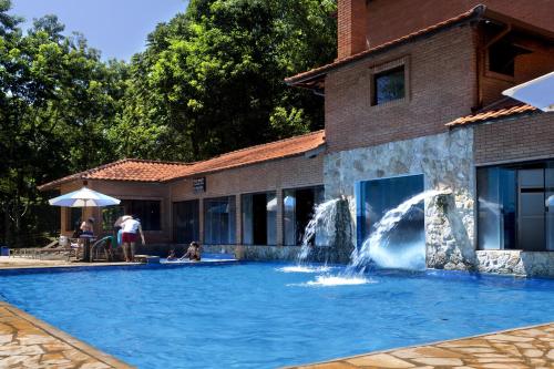 una piscina con una fontana di fronte a un edificio di Hotel Fazenda Campo dos Sonhos a Socorro