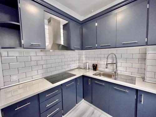 a kitchen with blue cabinets and a sink at Casa Tessita by Gloove in Alicante