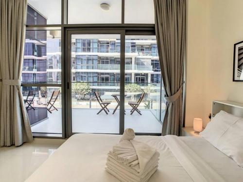 a bedroom with a bed and a large window at Key View - Loreto 3B, Damac Hills in Dubai Marina