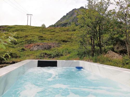 a bath tub filled with water in a field at Modern & Cozy Apartments Close To Nature, West Lofoten in Sørvågen