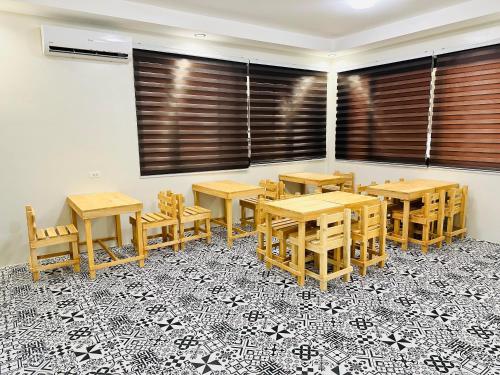 a dining room with wooden tables and chairs on a tile floor at Villa Del Cascel in Bulala