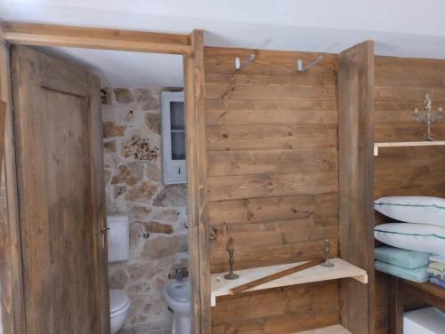 een badkamer met een toilet en een stenen muur bij Trullo Nicola in Ceglie Messapica