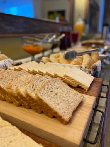 a bunch of bread on a wooden cutting board at Hotel Fabris in Nova Friburgo