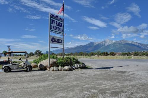 a street sign with a sign for a parking lot at Snowy Peaks RV Park in Buena Vista