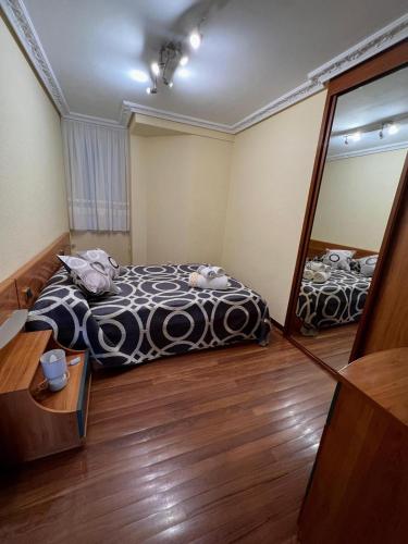 a bedroom with a black and white bed and a mirror at Apto Anita 5 ' playa Brazomar in Castro-Urdiales