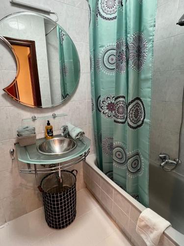 a bathroom with a sink and a shower curtain at Apto Anita 5 ' playa Brazomar in Castro-Urdiales