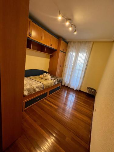 a small bedroom with a bed and a wooden floor at Apto Anita 5 ' playa Brazomar in Castro-Urdiales