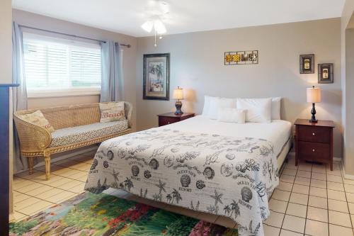 a bedroom with a bed and a chair and a window at Summit 723 in Panama City Beach