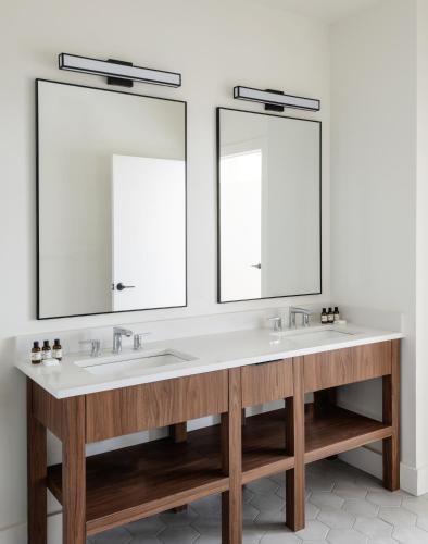 a bathroom with two sinks and two mirrors at Roost Baltimore in Baltimore