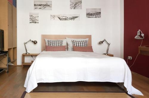 um quarto com uma grande cama branca e 2 candeeiros em Art-Apartment-Leo em Bremerhaven