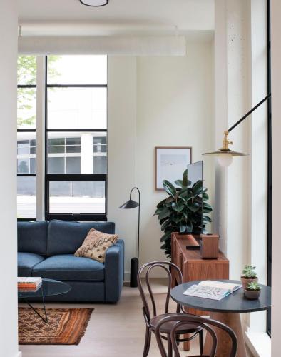 a living room with a blue couch and a table at Roost Baltimore in Baltimore