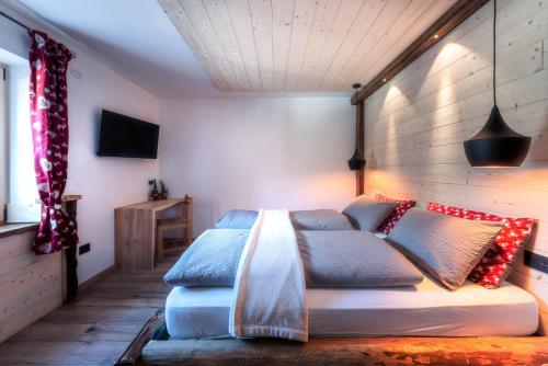 a bedroom with a bed with blue and red pillows at Ciasa Marizana in Soraga