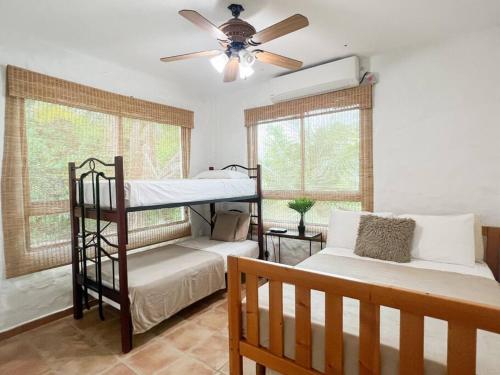 a bedroom with two bunk beds and a ceiling fan at Live an adventure in Taboga 1 in Taboga