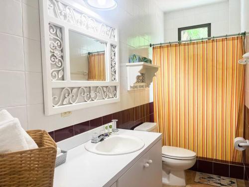 ein Badezimmer mit einem Waschbecken, einem WC und einem Spiegel in der Unterkunft Live an adventure in Taboga 1 in Taboga