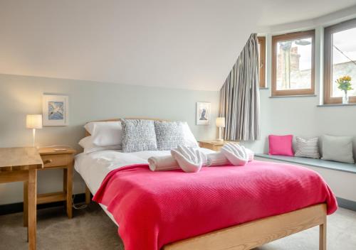 ein Schlafzimmer mit einem Bett mit einer roten Decke in der Unterkunft Midsomer House in Aldeburgh