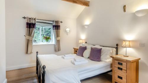 Schlafzimmer mit einem Bett und einem Fenster in der Unterkunft Woodpecker in Chinley