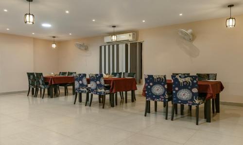a dining room with tables and chairs with blue and white cushions at Itsy Hotels Kashi Grand, BHU in Varanasi