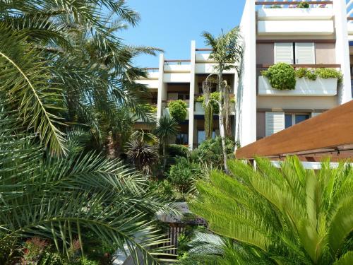 a building with palm trees and plants in front of it at Sitia Bay in Sitia