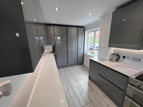 a kitchen with black and white cabinets and a counter at Thistle House - hot tub, parking in Kent