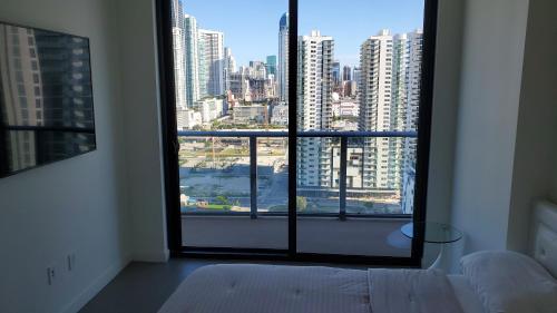 a bedroom with a large window with a view of a city at Canvas Condo in Miami