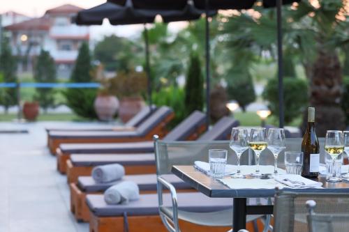 a row of tables and chairs with wine glasses at Hotel Yakinthos in Paralia Katerinis