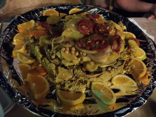 a plate of food with vegetables and lemons on a table at Ciao Hotel in Nuweiba