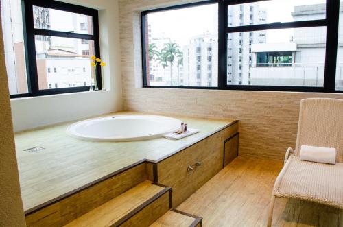 a bathroom with a sink and two windows at Royal Boutique Savassi Hotel in Belo Horizonte