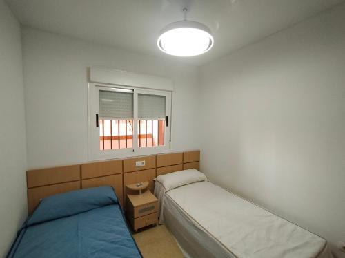 - une chambre avec 2 lits et une fenêtre dans l'établissement ACV - Torremar-2ª linea planta 2 Frontal 3h, à Oropesa del Mar