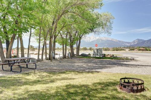 a park with a picnic table and trees and mountains at Snowy Peaks RV Park in Buena Vista