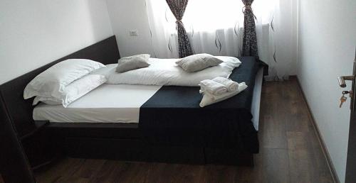 a bed with white sheets and pillows in a room at Casa Atelier Transfăgărășan in Corbeni