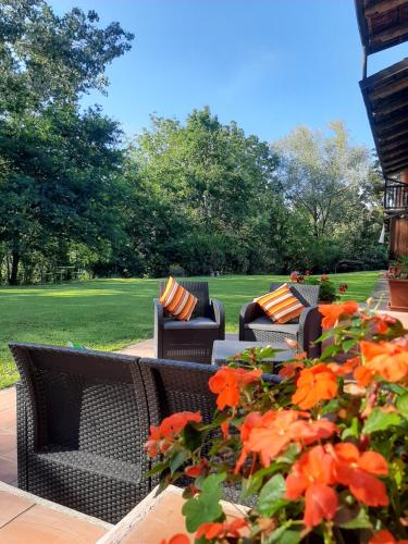 a patio with two chairs and a bush with orange flowers at La Collina dei Passeri in Pocapaglia
