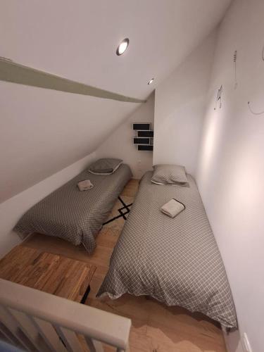 2 camas en una habitación pequeña con ático en Le triplex Côté plage plein Sud, en Courseulles-sur-Mer