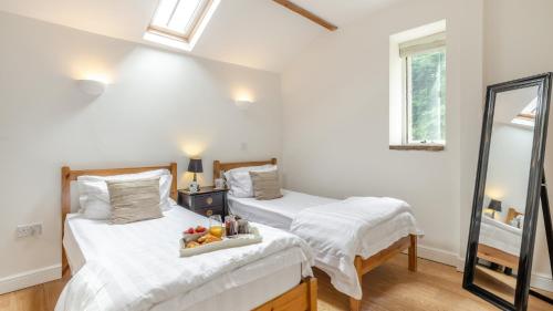 sypialnia z 2 łóżkami i tacą z owocami w obiekcie Kestrel Cottage w mieście Chinley