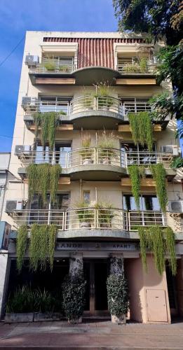 a building with plants on the balconies of it at Apart Hotel Rio Grande in Rosario
