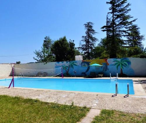 une grande piscine avec une fresque murale dans l'établissement Le Relais de la RN7, à Châteauneuf-du-Rhône