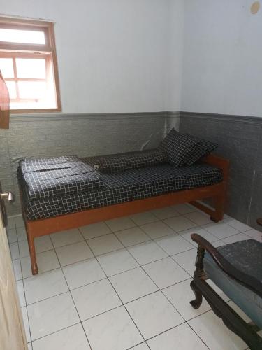 uma cama num quarto com uma janela em Budhis Home em Bromo