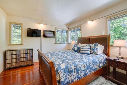 a bedroom with a bed and a tv and windows at Waterfront Coos Bay Retreat with Kayaks! in Coos Bay