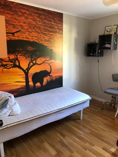 un dormitorio con una pintura de un elefante y un árbol en Havsnära villa, närhet till stan en Värmdö