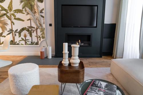 a living room with a fireplace and a tv at Coco: hypercentre-2chambres-parking-zen... in Saint-Étienne