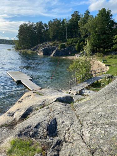 ein Dock auf einem Wasserkörper mit Bänken in der Unterkunft Havsnära villa, närhet till stan in Värmdö