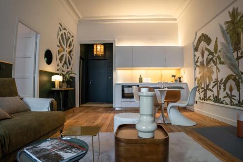 a living room with a couch and a kitchen at Coco: hypercentre-2chambres-parking-zen... in Saint-Étienne