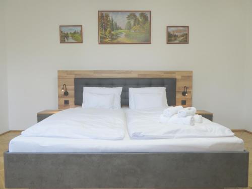 a large bed with two white towels on it at Hegyköz Vendégház 