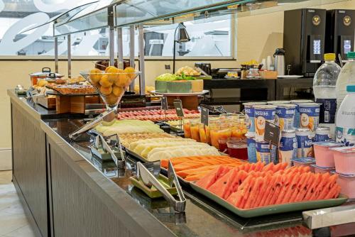 a buffet line with many different types of food at ROCKEFELLER by Slaviero Hotéis in Curitiba