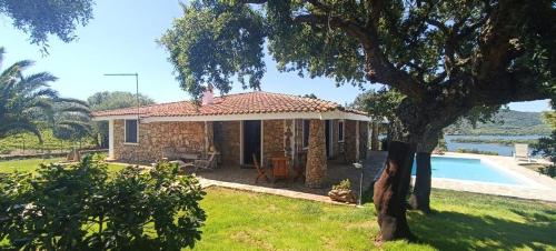 a stone house with a pool in the yard at Villa De La Seliga in Sant Antonio Di Gallura