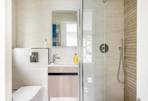a bathroom with a shower and a toilet and a sink at Arlington - private room and en-suite in Woking
